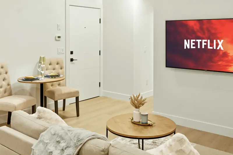 Calgary suite living room with wall-mounted TV and bistro dining table